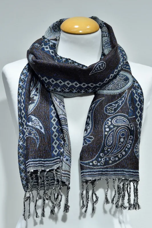 Mindre blå ullsjal med paisleymönster och fransar, virad runt halsen på en vit skyltdocka.
