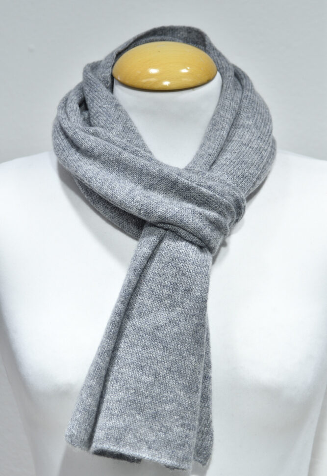 Liten grå halsduk i 100% cashmere knuten runt en skyltdockas hals.