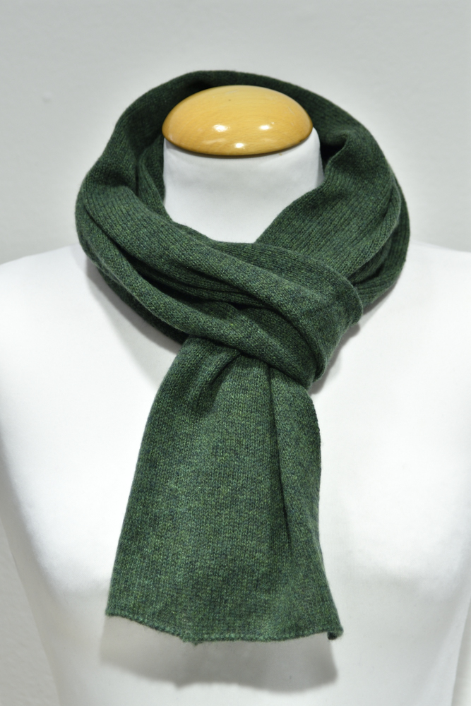 Liten grön halsduk i 100% cashmere knuten runt en skyltdockas hals.