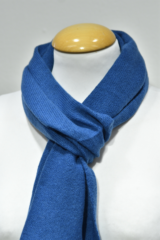 Liten klarblå halsduk i 100% cashmere knuten runt en skyltdockas hals.