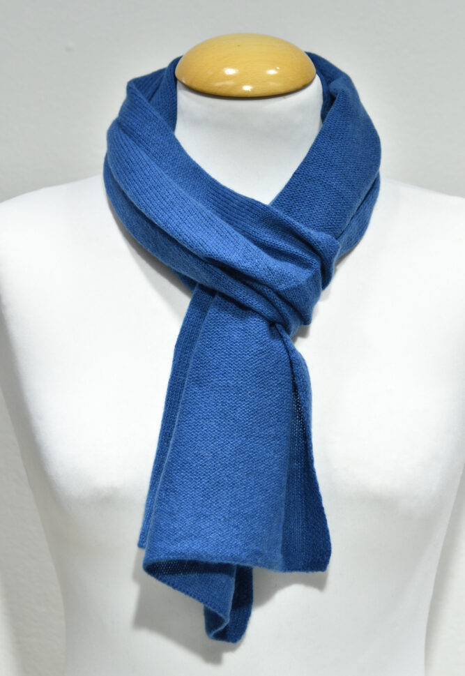 Liten klarblå halsduk i 100% cashmere knuten runt en skyltdockas hals.