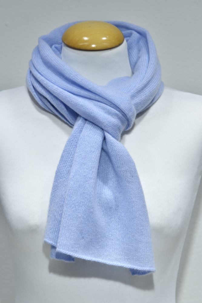 Liten ljusblå halsduk i 100% cashmere knuten runt en skyltdockas hals.
