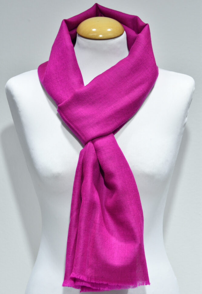 Handvävd pashminasjal i rosa på vit provdocka, med fransad kant.