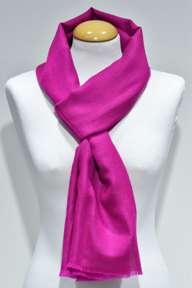 Handvävd pashminasjal i rosa på vit provdocka, med fransad kant.